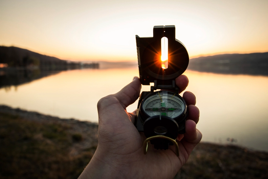 hand holding lensatic compass pointing